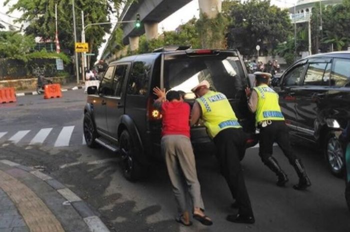 Polisi mendorong mobil mogok, netizen fokus sama mobilnya
