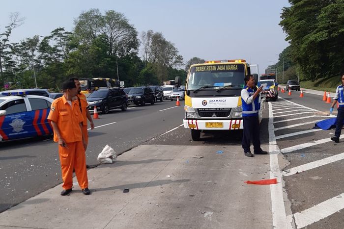 Petugas mengamankan lokasi kecelakaan tunggal Suzuki APV di Tol Jagorawi, Jawa Barat.