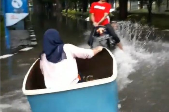 Mahasiswi asyik main 'motor boat' saat kampusnya kebanjiran