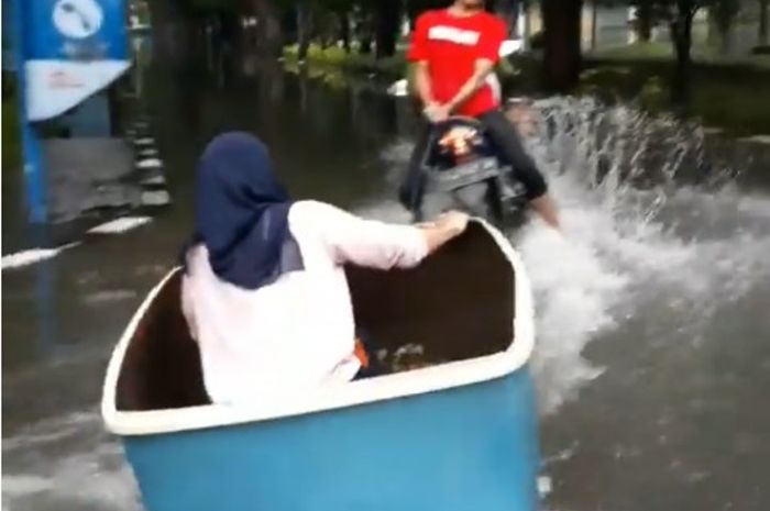Mahasiswi asyik main 'motor boat' saat kampusnya kebanjiran