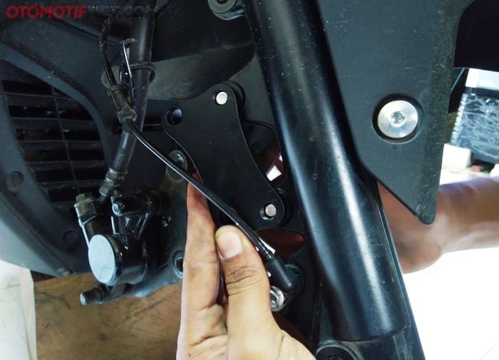 Pemasangan braket kaliper baut yang ke suspensi depan NMAX dari sisi belakang