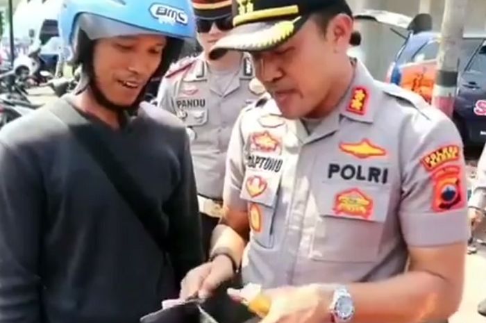 Kapolres Kudus, AKBP Saptono memeriksa dompet pedagang tempe yang terjaring razia.