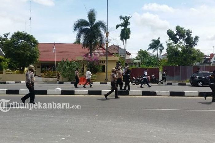 Polisi bersenjata lengkap memburu pelaku penyerangan Polda Riau, Rabu (16/5/2018)