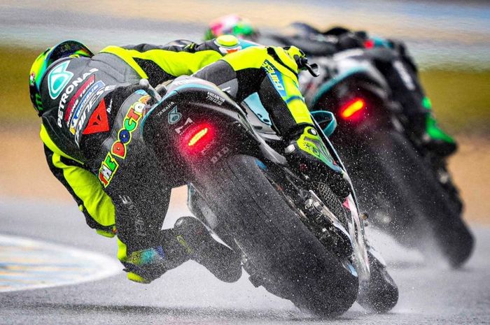 Valentino Rossi (belakang) berbicara mengenai balap basah