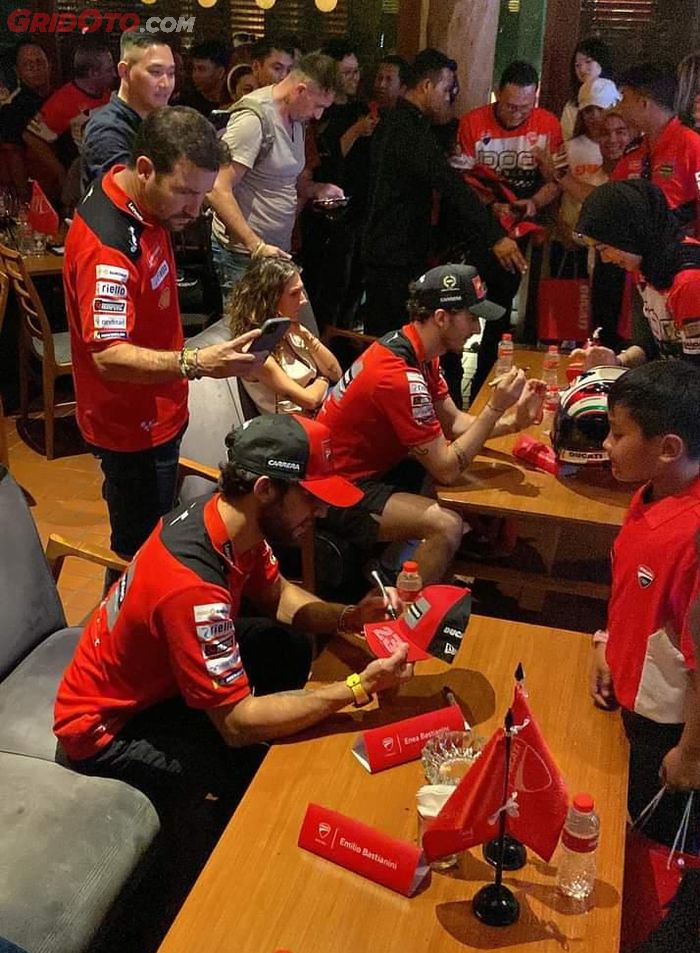 Pecco Bagnaian dan Enea Bastianini menandatangani memorabilia fans Ducati 