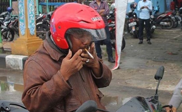 Pemotor dilarang merokok saat naik motor, bisa kena denda Rp 750 ribu.