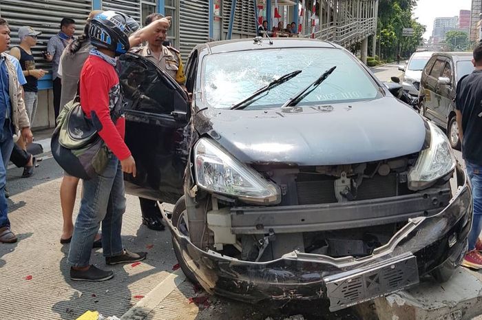 Nissan Grand Livina menabrak separator busway karena terlibat tabrak lari