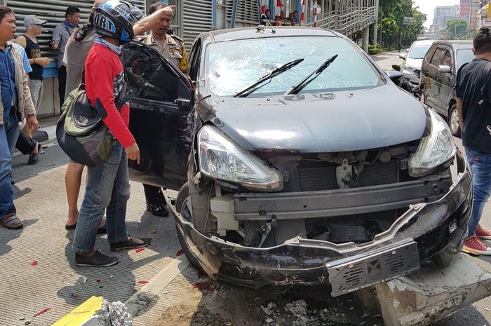 Nissan Grand Livina menabrak separator busway karena terlibat tabrak lari