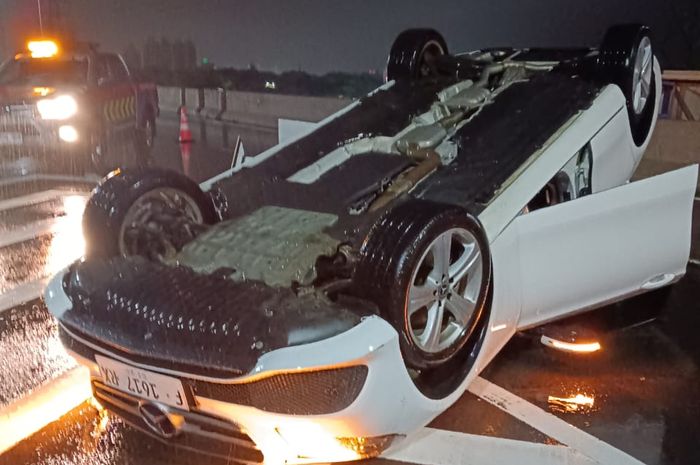 Sebuah Mercedes Benz E250 dengan plat nomor F 1617 RX mengalami kecelakaan hingga terbalik