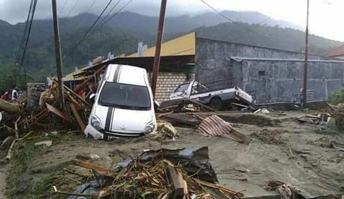 Toyota Agya terlihat tersangkut di antara dua tiang listrik