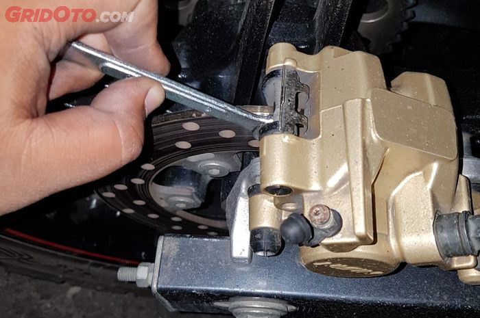 Bengkek kampas rem dengan menggunakan kunci atau obeng 8 