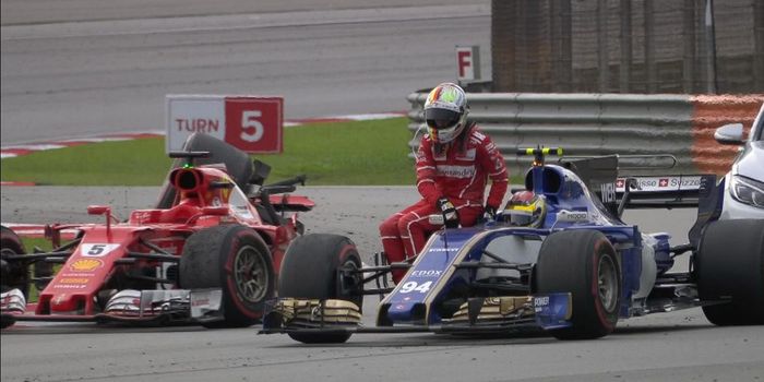 Sebastian Vettel membonceng mobil pembalap lain dan meninggalkan mobilnya yang rusak usai GP Malaysi