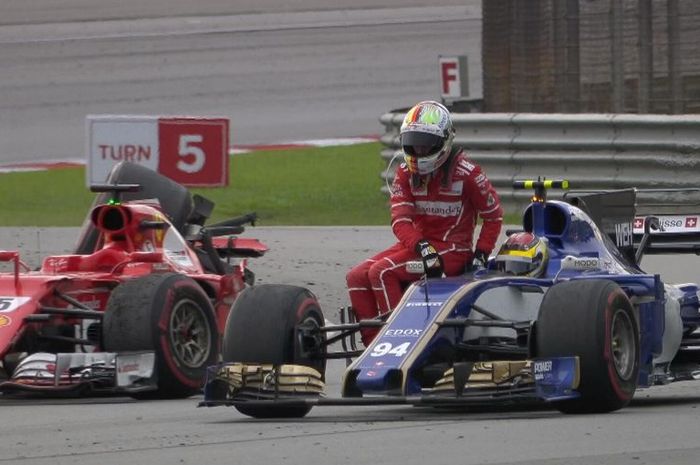 Sebastian Vettel membonceng mobil pembalap lain dan meninggalkan mobilnya yang rusak usai GP Malaysia 2017.