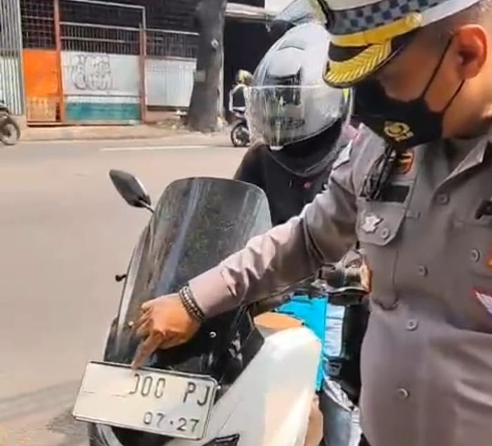 Pelat nomor ditempel lakban putih untuk hindari tilang elektronik