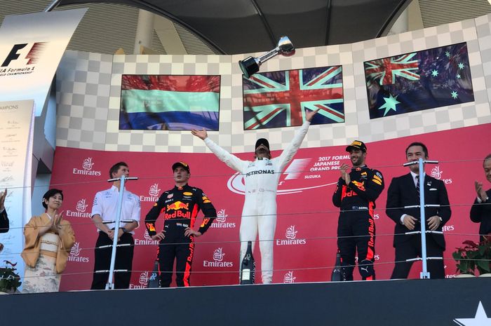 Lewis Hamilton melempar piala kemenangan yang ia dapatkan di F1 Jepang 2017