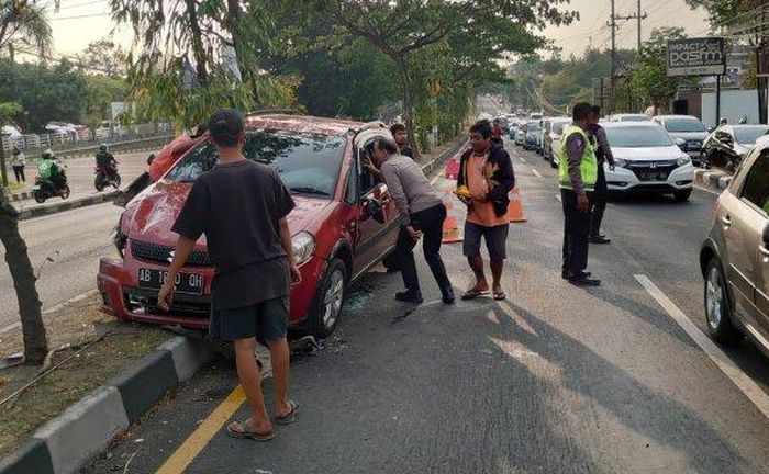 Polisi dibantu warga berhasil mengevakuasi Suzuki SX4 yang sebelumnya terbalik di Jl Padjajaran Ringroad Sleman, Yogyakarta