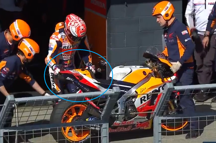 Marc Marquez memegang motornya yang rusak usai tabrakan di MotoGP Australia