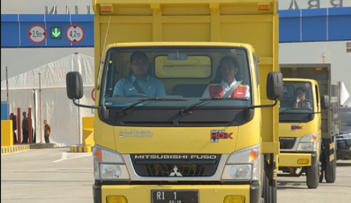 Jokowi bersama pria berbaju biru meresmikan tol Ngawi-Kertosono menggunakan truk Fuso.