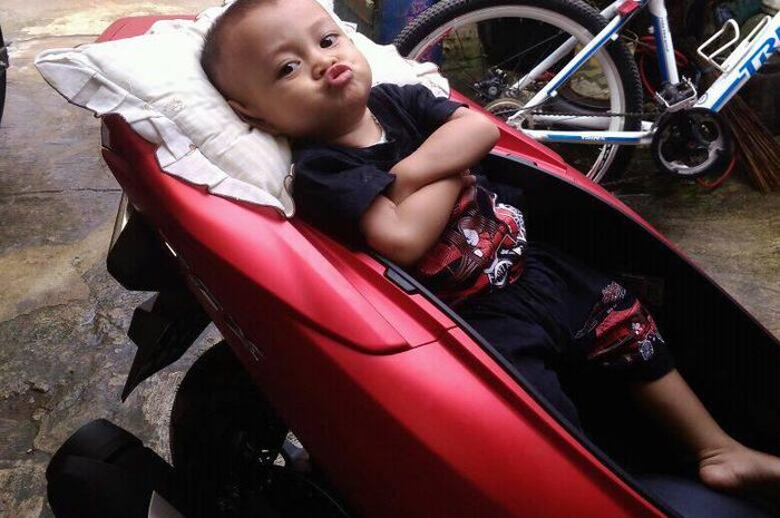 Anak balita berpose tidur-tiduran di bagasi All New Honda PCX 150