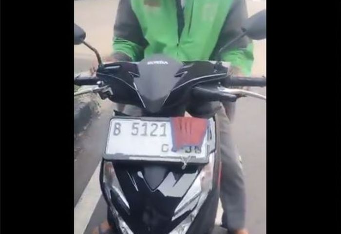 Bagian ujung belakang pelat nomor Honda BeAT milik pengendara ojek online yang ditutup masker hidung untuk hindari tilang elektronik