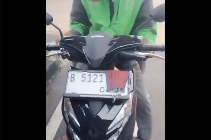 Bagian ujung belakang pelat nomor Honda BeAT milik pengendara ojek online yang ditutup masker hidung untuk hindari tilang elektronik
