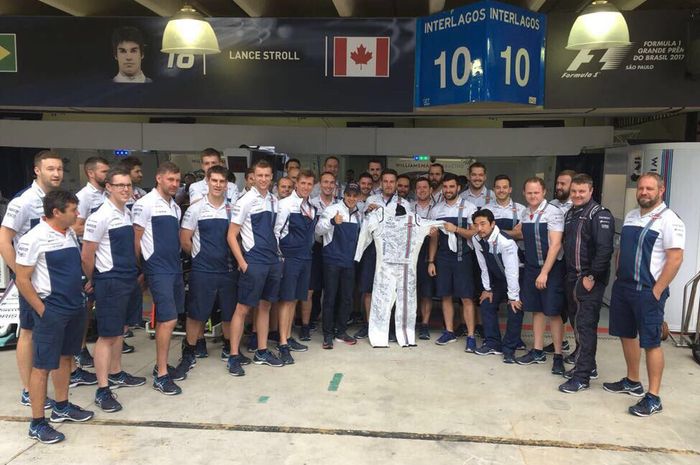 Felipe Massa (sebalah kiri pakai topi memegang baju balap) mendapat kenang-kenangan berupa baju balap yang ditandatangani semua mekanik tim Williams