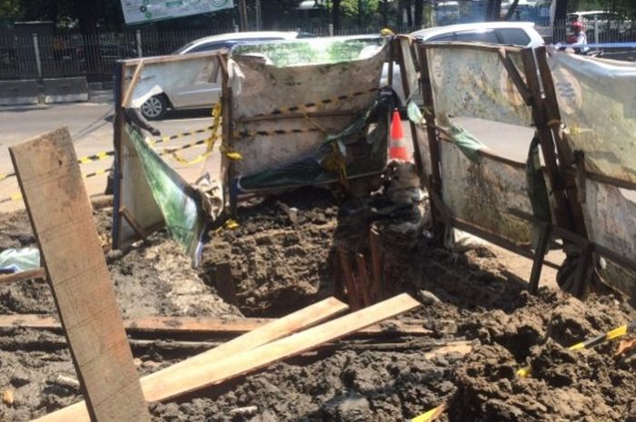 Di balik hiruk-pikuk lalu lintas, seorang pekerja tewas di lubang di bawah jalan