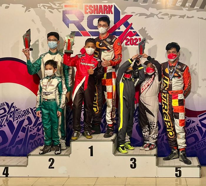 Qarrar Firhand Ali (baju balap warna merah-hitam) berdiri di podium pertama saat menerima trofi Tanada Racing Team sebagai tim terbaik