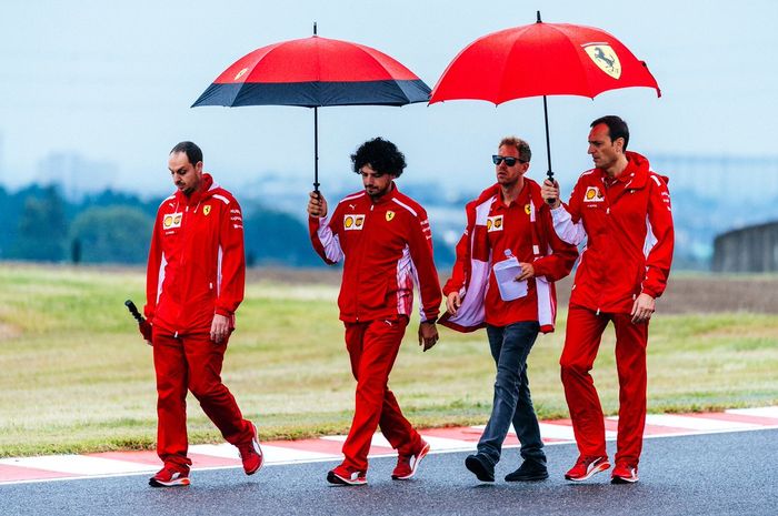 Sebastian Vettel dan kru timnya saat menijau trek Suzuka hari Kamis yang sempat diguyur hujan