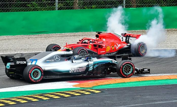 Mobil Sebastian Vettel melintir saat bersenggolan dengan mobil Lewis Hamilton tak lama setelah start GP F1 Italia