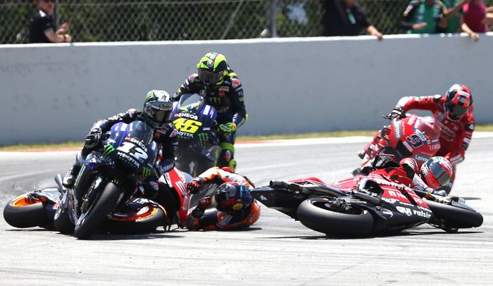 Andrea Dovizioso (kanan) jatuh setelah diseruduk Jorge Lorenzo (kiri, jatuh) di lap kedua MotoGP Catalunya