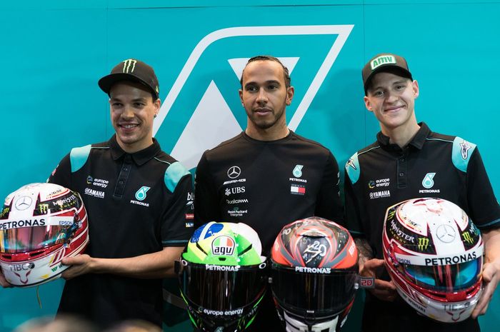 Lewis Hamilton memberikan helm balapnya kepada dua pembalap Petronas Yamaha SRT saat berkunjung ke MotoGP Qatar