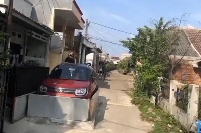 satu unit Suzuki Ignis parkir sembarangan menghalangi jalan di sebuah perumahan.