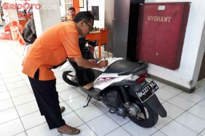 Petugas sedang mengurus motor kiriman