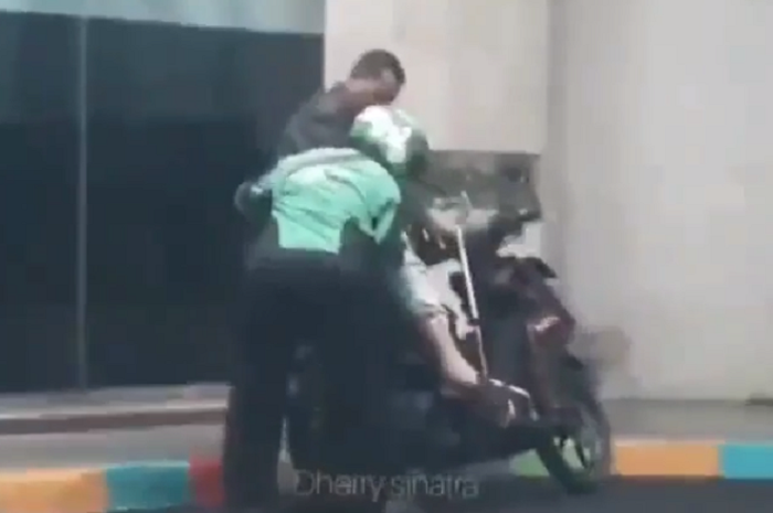 Driver ojol bantu penumpangnya yang sakit turun dari motor