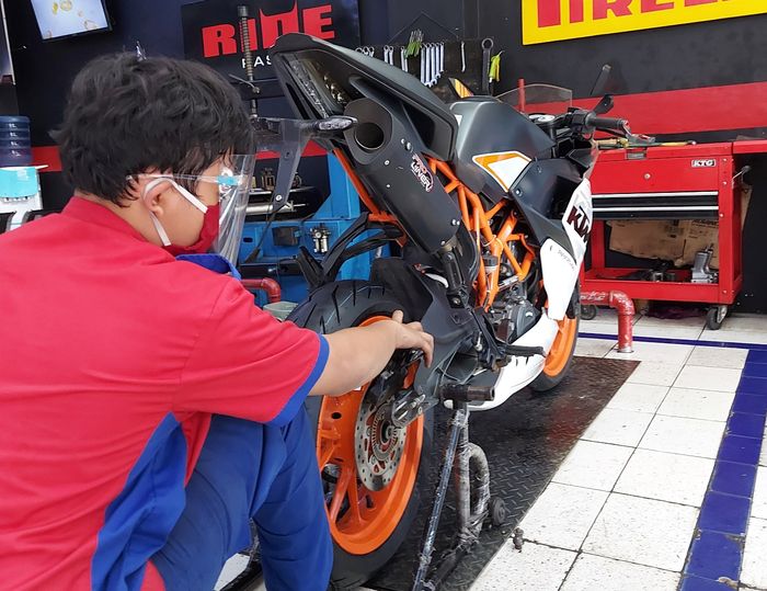 Mekanik Shop&Bike sedang melakukan perbaikan motor konsumennya.