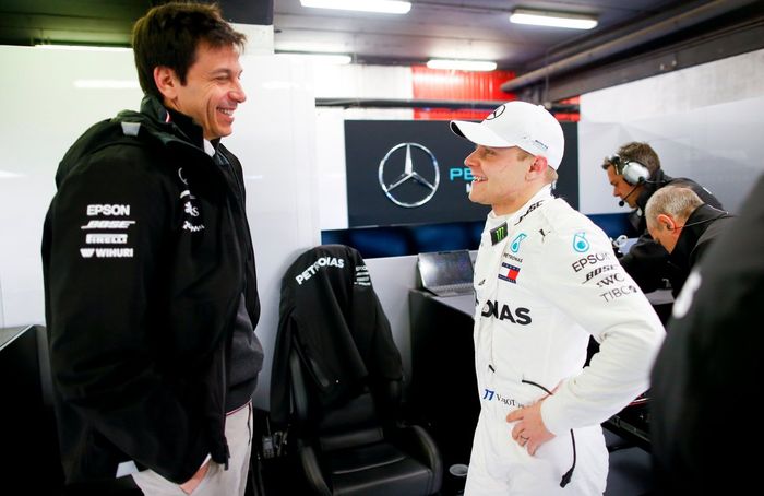 Toto Wolff  tengah ngobrol dengan Valtteri Bottas pada tes pramusim Barcelona, baju balap dan kru tim Mercedes kini dihias label merek Tommy Hilfiger dengan warna khas merah-putih-biru