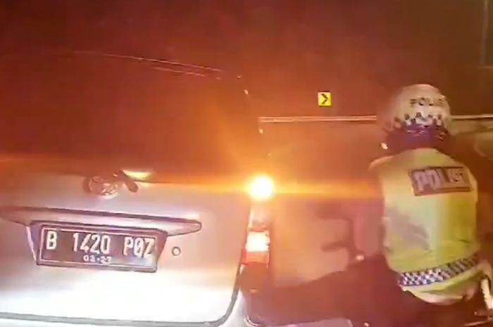 Personil Satlantas Polres Subang membantu mendorong Toyota Avanza milik pemudik yang mogok di Tol