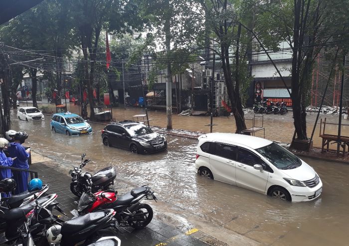 Beberapa mobil yang masih dapat melintasi genangan banjir di Jalan Taman Kemang, Jakarta Selatan