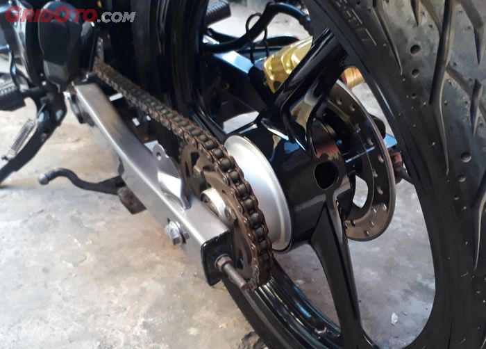 Ilustrasi arm belakang motor bekas yang masih lurus.