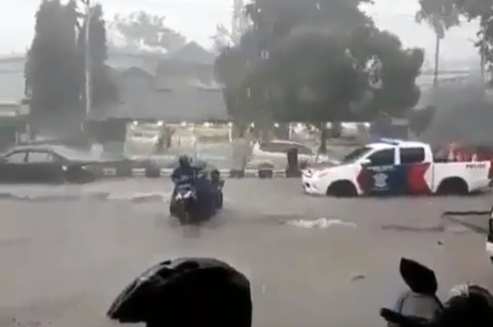 Polisi rela hujan dan terjang banjir bantu pemotor yang motornya mogok