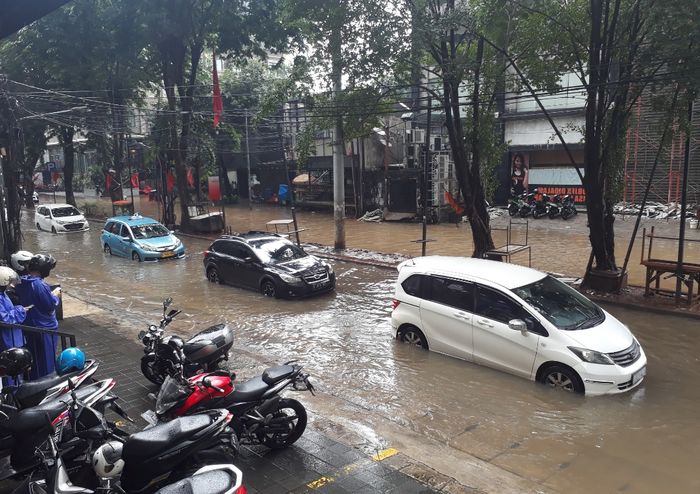 Beberapa mobil yang masih dapat melintasi genangan banjir di Jalan Taman Kemang, Jakarta Selatan