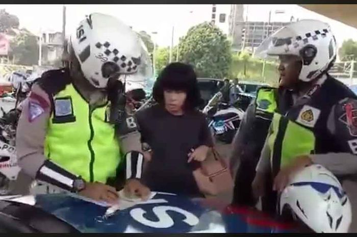 Seorang wanita yang tidak terima diberi sangsi tilang oleh petugas Polisi