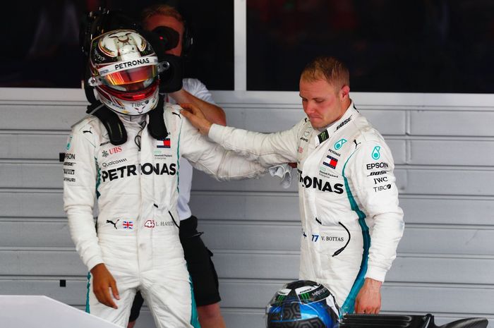 Lewis Hamilton (kiri) menghampiri Valtteri Bottas setelah finish terdepan di F1 Rusia