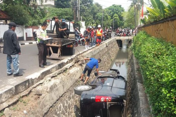 Daihatsu Xenia hitam terperosok ke dalam parit di Darmawangsa, Jakarta Selatan