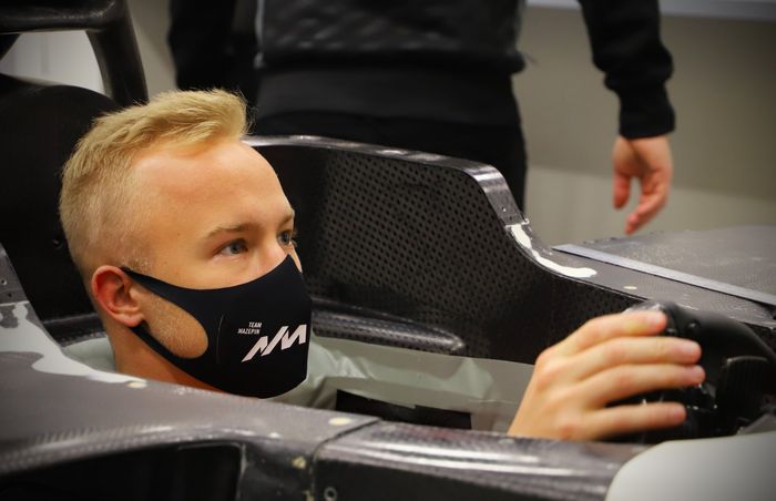 Nikita Mazepin sedang menyesuaikan posisi duduknya di kokpit mobil F1 tim Haas