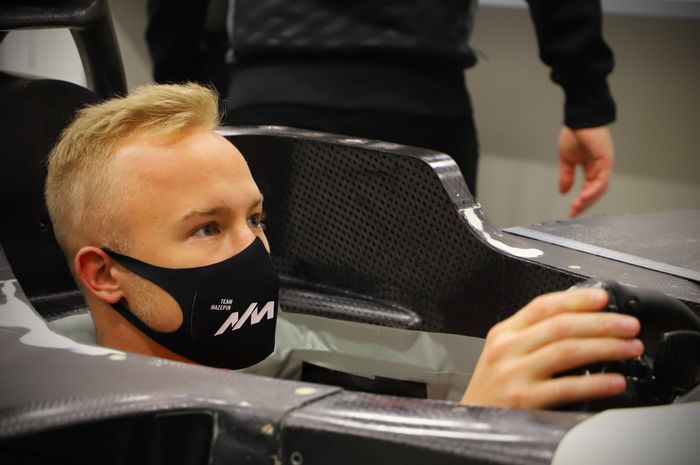 Nikita Mazepin sedang menyesuaikan posisi duduknya di kokpit mobil F1 tim Haas
