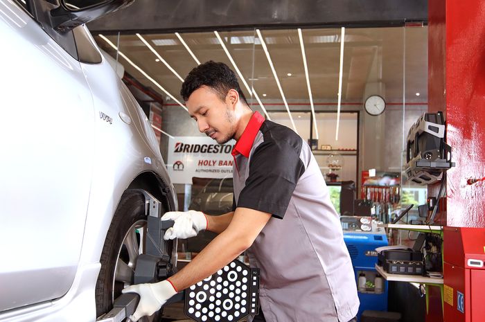 Ilustrasi pengecekan ban mobil sebelum road trip bersama keluarga