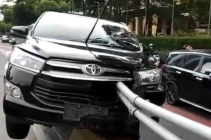 Toyota Kijang Innova nyangkut di atas separator Jalan Gatot Subroto, Jakarta Selatan, Minggu (3/12/2021)