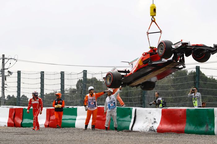 Mobil pembalap tim Scuderia Ferrari, Kimi Raikkonen dipindahkan dengan crane usai kecelakaan